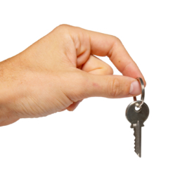 Silver key in a hand isolated on white.